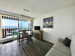a living room with a couch and a table and a television at Oceanide 72 by agence bru in Lacanau-Océan