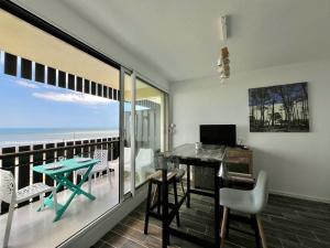 a room with a balcony with a desk and a table at Oceanide 72 by agence bru in Lacanau-Océan