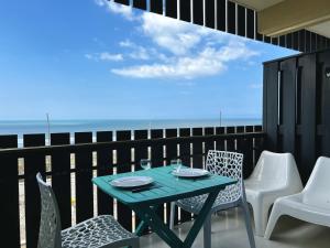 a table and chairs on a balcony with the ocean at Oceanide 72 by agence bru in Lacanau-Océan
