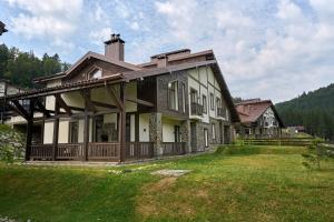 a large house on a hill with a grass yard at Die SONNE in Bukovel