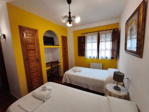 a hotel room with two beds and a table at El Humilladero in Mogarraz