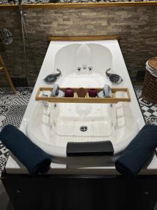 a white bath tub with two handles on a table at Relaxed appartment in Melun