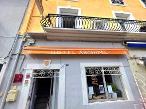 a hotel entrance with a balcony on a building at Hôtel Archipel in Balaruc-les-Bains