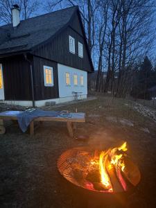 a fire pit in front of a house at Chaloupka Dvě Sestry in Kořenov