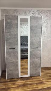 a mirror on a wall next to a room with a bed at Apartmani AX in Pančevo +1 photo