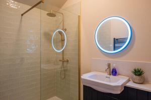 a bathroom with a shower and a sink and a mirror at Luxury Riverside Duplex Apartment for 4 in Wilton