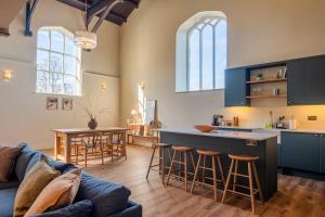 a kitchen and living room with a couch and a table at Luxury Riverside Duplex Apartment for 4 in Wilton