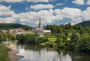 a river in front of a town with a church at Luxury Riverside Duplex Apartment for 4 in Wilton