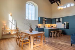 a kitchen with blue cabinets and a table and chairs at Luxury Riverside Duplex Apartment for 4 in Wilton +22 photos