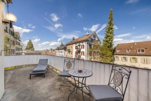a patio with two chairs and a table on a balcony at Apartments Sank Georgenstrasse in St. Gallen