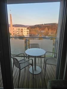 a table and chairs on a balcony with a view at 365 apartmány AUPARK in Piešťany
