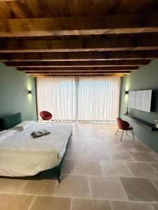 a bedroom with a large bed and two chairs at Dimora Rosaspina Suite Eden e Suite Platinum in Adro