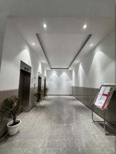 an empty hallway with two potted plants in a building at Hazelnut -Expo India centre in Greater Noida