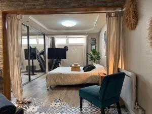 a bedroom with a bed and a chair and a television at Relaxed appartment in Melun