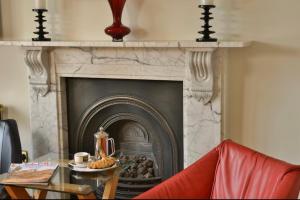 a fireplace with a table in front of it at Taunton House Hotel in Taunton