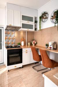 a kitchen with white cabinets and a black oven at Apartament Salina Turda in Turda