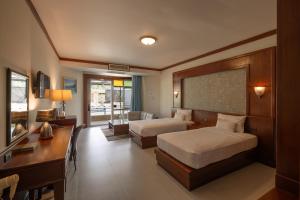 a hotel room with two beds and a desk at Erawan Phangnga Hotel, Natai Beach in Ban Na Phong