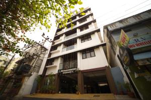a tall white building with stairs in front of it at Sri Saai Surguru Residency in Pondicherry