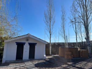a small white shed with a fence and trees at Alentejo Villa Nordic Spa & Pool in Santo António do Alcôrrego +35 photos