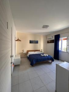 a bedroom with a bed with a blue blanket at A Due Passi dal Centro in Favignana