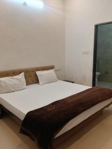 a bedroom with a large bed with a brown blanket at Hotel Viny villa in Udaipur