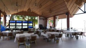 a restaurant with white tables and chairs and windows at Koh Rong New Beach Resort in Koh Rong Island