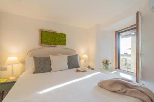 a bedroom with a large white bed and a window at La Casa di Pietro in Blevio