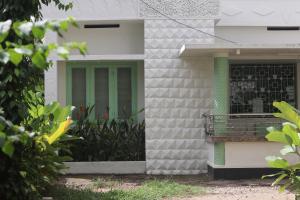 a building with a green door and a balcony at Calathea home varkala beach in Varkala