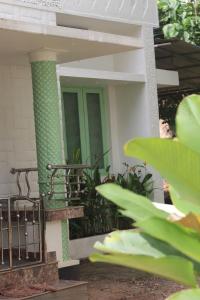 a front porch of a house with a green door at Calathea home varkala beach in Varkala +11 photos