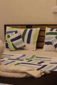a bed with pillows and a comforter on it at Calathea home varkala beach in Varkala