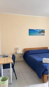 a bedroom with a bed and a table and a picture at A Due Passi dal Centro in Favignana