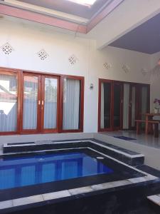 a large swimming pool in a living room with at Villa Bianca Lovina by GEMA MANAGEMENT BALI in Lovina