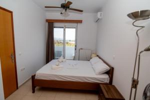a small bedroom with a bed with a window at Olive Paradise Maison in Kos