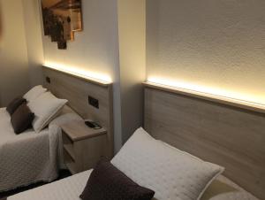 a hotel room with a bed and a side table at Pensión Plaza in Quintáns