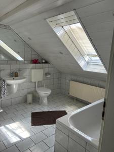 a bathroom with a tub and a sink and a skylight at Ferienwohnung2 Renate Strohhöfer in Hirschaid