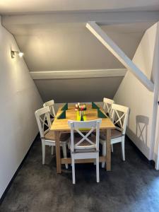 a wooden table with chairs and a vase of flowers on it at Ferienwohnung2 Renate Strohhöfer in Hirschaid +3 photos