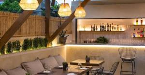 a restaurant with tables and chairs and a bar at Little Blue Doors Studios in Samos