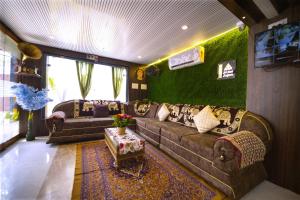 a living room with a couch and a tv at Sri Saai Surguru Residency in Pondicherry