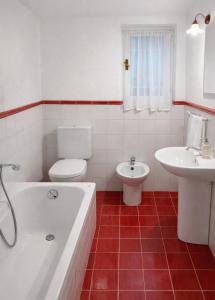 a bathroom with a tub and a toilet and a sink at Casa Lapè in Levanto