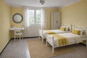 a bedroom with two beds and a table and a mirror at Casa Lapè in Levanto