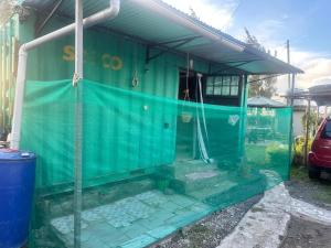 a green house with a window on the side of it at Brighton court in Jomo Kenyatta Airport Nairobi