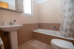 a bathroom with a tub and a toilet and a sink at Olive Paradise Maison in Kos +38 photos