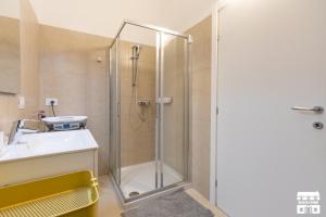 a shower with a glass door next to a sink at SANTA MARTA by Design Studio in Bellano +19 photos