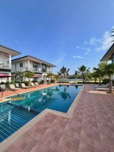 a swimming pool in front of a house at Swiss Resort in Ban Phe