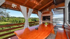 a large wooden table on a porch with a fireplace at Villa Vinea by Villas Guide in Novakovec