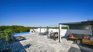 a patio with a couch and a table and a pool at Villa Vinea by Villas Guide in Novakovec