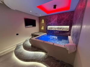 a large bathroom with a large tub with purple tiles at Buono Hotel in Naples