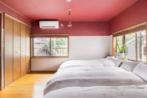 a bedroom with a large bed and a red wall at BLIKIYA Doma in Fujiyoshida