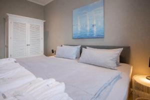 a bedroom with a large bed with white pillows at Inselrose in Juist