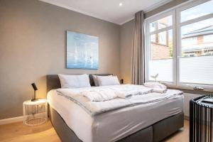 a bedroom with a large bed and a window at Inselrose in Juist